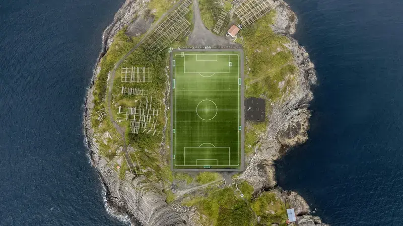 El campo de fútbol de Henningsvær, en las islas Lofoten (Noruega), rodeado por el mar. Para muchas niñas, tener dónde jugar se parece a esto: el campo existe, pero llegar hasta él no siempre es fácil.