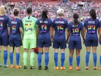 La selección femenina de Estados Unidos forma antes de un amistoso contra China disputado en Cleveland el 12 de junio de 2018, con dorsales en los colores del arcoíris.