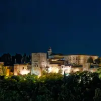 Vista de la Alhambra iluminada de noche.