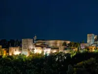 Vista de la Alhambra iluminada de noche.
