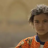 Una joven observa el entorno en Irak.